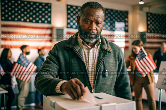 President elections. A black man votes for the new president of the United States of America and puts a form in the ballot box against the background of the American flag. Стоковое AI-изображение, AI-художник Photojuli / Фотобанк Лори