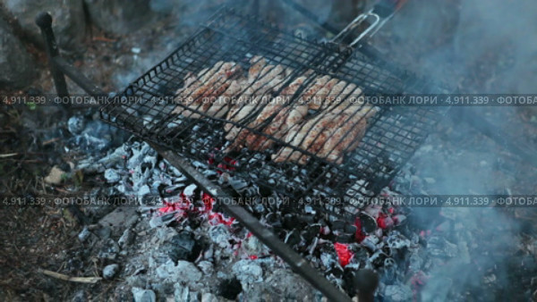 Приготовление мяса на решетке на углях костра. Стоковое видео, видеограф Кекяляйнен Андрей / Фотобанк Лори