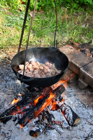 Приготовление пищи на открытом огне. Кусочки мяса обжариваются в казане. Стоковое фото, фотограф Щеголева Ольга / Фотобанк Лори