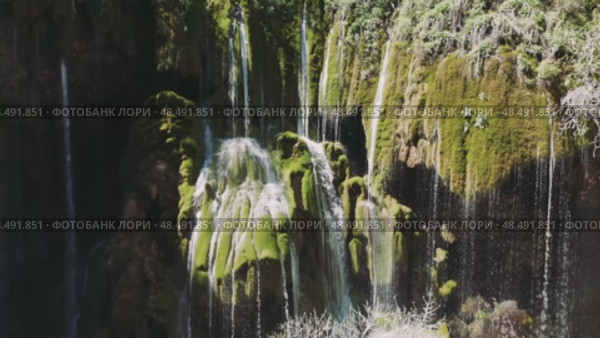 Pristine waterfall tumbling over moss-covered stones, sunlight piercing misty veil, revealing verdant turkish landscape's enchanting natural splendor. Стоковое видео, видеограф ILIA GOROKHOV / Фотобанк Лори