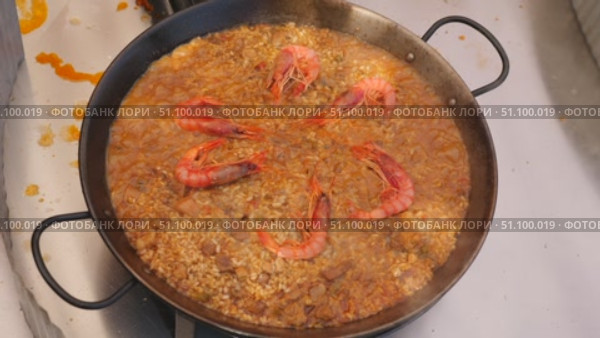 Process of cooking paella with seafood, dish is decorated with huge tiger shrimps. Стоковое видео, видеограф Яков Филимонов / Фотобанк Лори