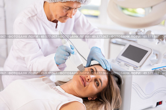 Professional female cosmetologist doing deep cleansing of facial skin of woman in beauty salon. Стоковое фото, фотограф Яков Филимонов / Фотобанк Лори