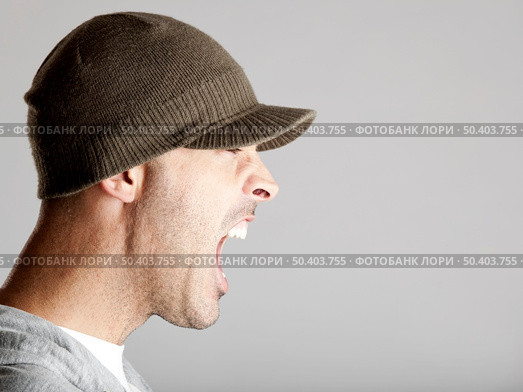 Profile portrait of a young man yelling, isolated on a gray background. Стоковое фото, агентство Ingram Publishing / Фотобанк Лори