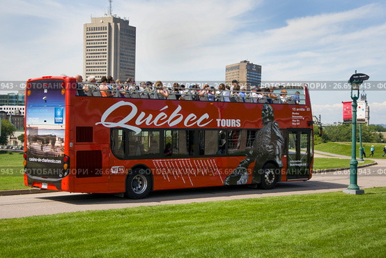 QUEBEC, CANADA - AUGUST 20, 2014: Sightseeing red tourist bus rides at the Parc des Champs-de-Bataille National Battlefields Park Quebec, Canada. Редакционное фото, фотограф Irina Kuchugurina/Gaudy / Фотобанк Лори
