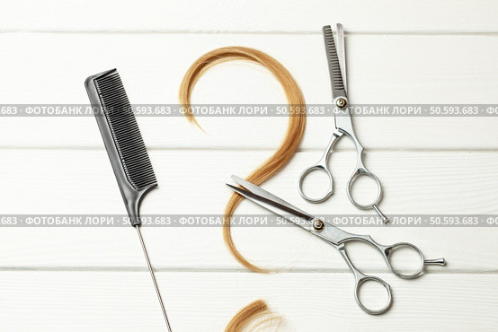 Question mark made of curl hair. Concept of how to choose a hairstyle or hairdresser. White wood background with hair and thinning scissors. Стоковое фото, агентство Ingram Publishing / Фотобанк Лори
