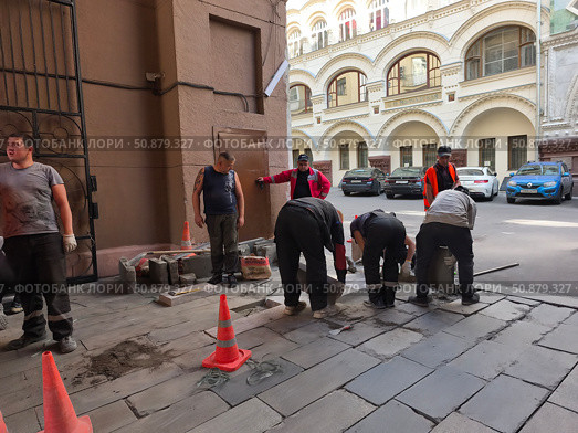 Рабочие укладывают тротуарную плитку во дворе в Москве. Редакционное фото, фотограф Мария Сергеева / Фотобанк Лори