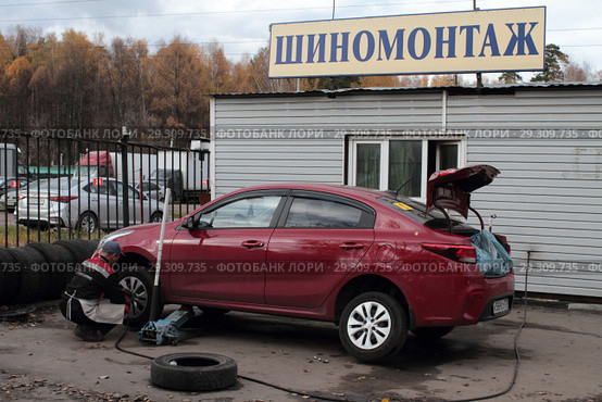 Рабочий шиномонтажа меняет колёса в Балашихе на улице Мира (2018 год). Редакционное фото, фотограф Дмитрий Неумоин / Фотобанк Лори
