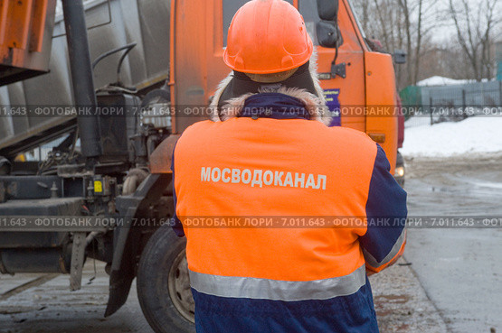 Работник Мосводоканала следит за разгрузкой снега, снегоплавильный пункт, Москва (2015 год). Редакционное фото, фотограф Малышев Андрей / Фотобанк Лори