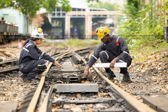 Railway technicians and engineers, Working on the train tracks at train station. Стоковое фото, агентство Ingram Publishing / Фотобанк Лори