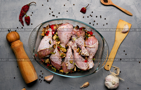 Raw chicken legs and lots of spice in a transparent dish on a grey background. Стоковое фото, фотограф Енваев Андрей / Фотобанк Лори