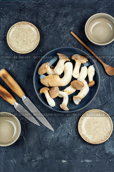 Raw forest rare delicious edible mushrooms on a table.. Uncooked champignon mushrooms in a bowl. Стоковое фото, агентство Ingram Publishing / Фотобанк Лори