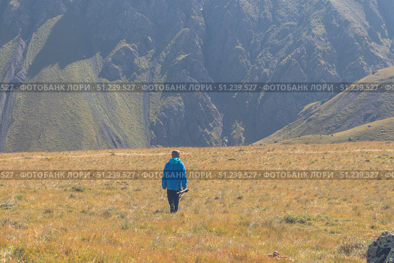 Rear view of boy walking with tripod against mountains background. Стоковое фото, фотограф Михаил Яковлев / Фотобанк Лори