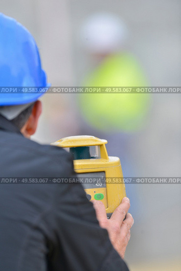 Rear view of surveyor using theodolite. Стоковое фото, агентство Ingram Publishing / Фотобанк Лори