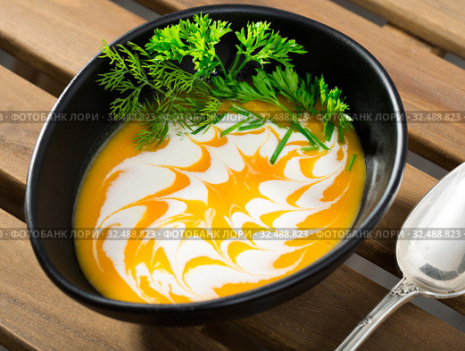 Recipe of pumpkin soup puree with ginger root - roast pumpkin in olive oil, beat in blender with vegetable broth. Add whisked cream with garlic and ginger. Serve with greens. Стоковое фото, фотограф Яков Филимонов / Фотобанк Лори