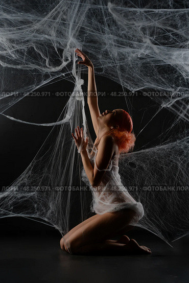 Red-haired woman entangled in a net trap resembling a spider web. Стоковое фото, фотограф Гурьянов Андрей / Фотобанк Лори