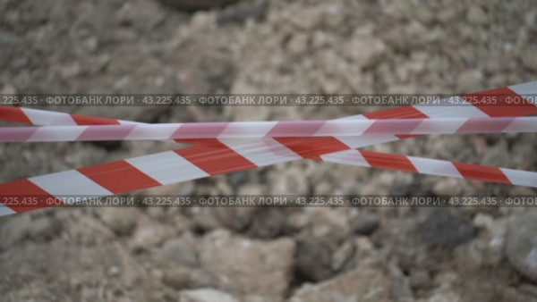 Red white barrier tape trenches. Focus on red and white barrier tape at construction site. Ribbons indicate dug trenches. Стоковое видео, видеограф svetograph / Фотобанк Лори