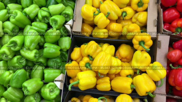 Red, yellow and green sweet bell peppers are on sale in supermarket, close up view as a background. Стоковое видео, видеограф Кекяляйнен Андрей / Фотобанк Лори