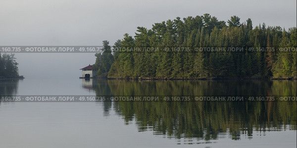 Reflection of trees on water, Lake of The Woods, Ontario, Canada. Стоковое фото, агентство Ingram Publishing / Фотобанк Лори