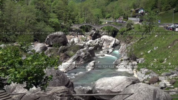 Река Верзаска и двугорбый мост в солнечный день. Швейцария. Май. Verzasca River and Bactrian Bridge on a sunny day. Switzerland. May. Стоковое видео, видеограф Горшков Александр / Фотобанк Лори