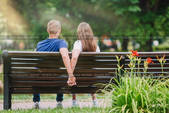 Relaxed young family on the bench in the park. Стоковое фото, фотограф Дмитрий Травников / Фотобанк Лори