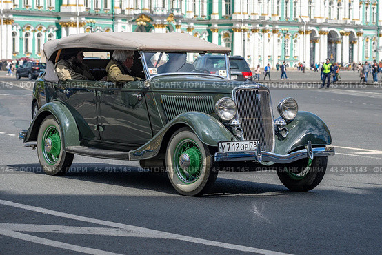 Ретро автомобиль Ford V8 Deluxe Phaeton на Дворцовой площади солнечным днем. Ежегодный парад ретротранспорта. Санкт-Петербург (2017 год). Редакционное фото, фотограф Виктор Карасев / Фотобанк Лори