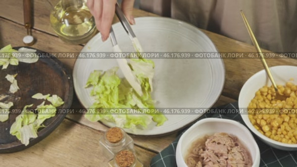 Ripe lettuce leaves are the foundation for making a salad with seafood and corn. Стоковое видео, видеограф Strunov David / Фотобанк Лори
