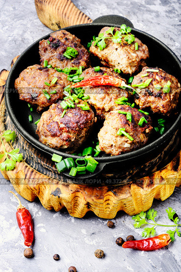 Roasted beef meatballs in cast-iron skillet.Delicious cutlet. Delicious meatballs in frying pan. Стоковое фото, агентство Ingram Publishing / Фотобанк Лори