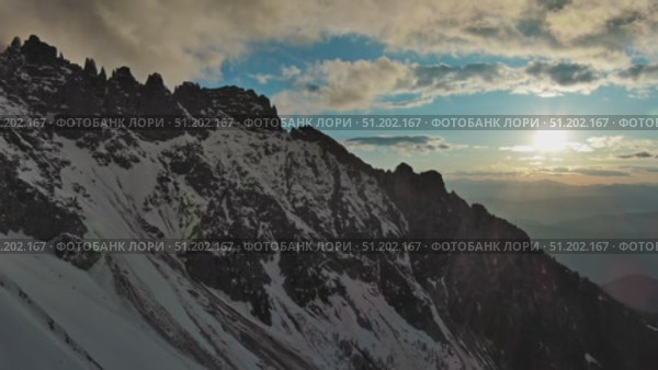 Rocky snow mountains and sunset sun. Стоковое видео, видеограф Михаил Коханчиков / Фотобанк Лори