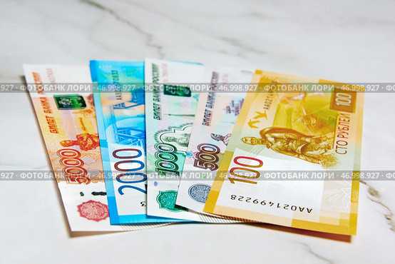 Российские деньги. Купюры 100 рублей, 500 рублей, 1000 рублей, 2000 рублей, 5000 рублей лежат на столе. Стоковое фото, фотограф Константин Козлов / Фотобанк Лори