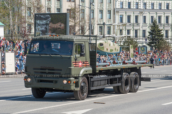Российский трёхосный грузовик КамАЗ-65117 с новым боевым беспилотником вертолетного типа "Катран-БПЛА" едет после парада в честь Дня Победы по Новому Арбату, Москва, вид сбоку (2018 год). Редакционное фото, фотограф Малышев Андрей / Фотобанк Лори