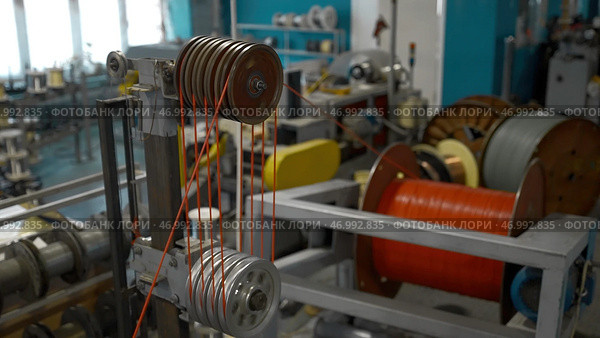Rotating and reeling metal threads bobbins at modern tire production plant. Стоковое фото, фотограф David Kashakhi / Фотобанк Лори