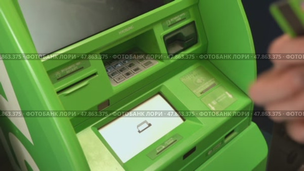 Russia, Sosnovy Bor, April 18, 2025 - Woman withdrawing cash at green atm. Редакционное видео, видеограф Андрей Знаменский / Фотобанк Лори