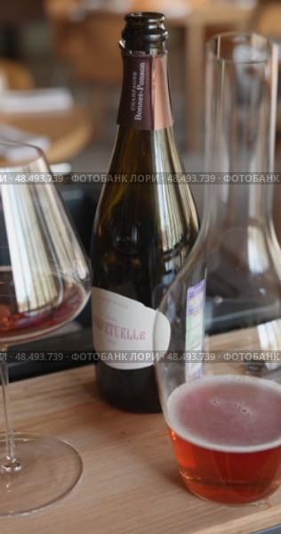 Russia, St.Petersburg, 24 April 2025: bottle of champagne is cooled in a niche with ice in the restaurant, local lighting, wine cabinet, decanters for sparkling wine. Редакционное видео, видеограф Vladimir Drozdin / Фотобанк Лори