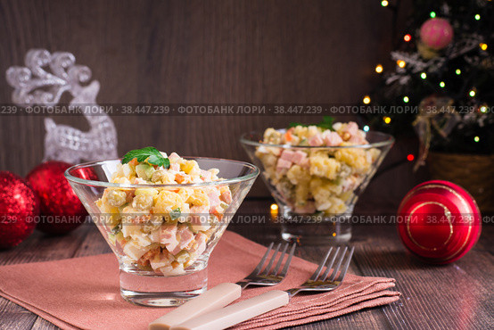 Russian olivier salad of sausage and boiled vegetables in bowls on a wooden table. Стоковое фото, фотограф Елена Руй / Фотобанк Лори
