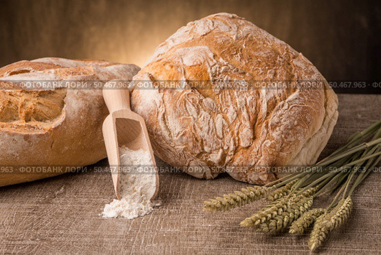 Rustic bread and wheat on an old vintage planked wood table. Стоковое фото, агентство Ingram Publishing / Фотобанк Лори
