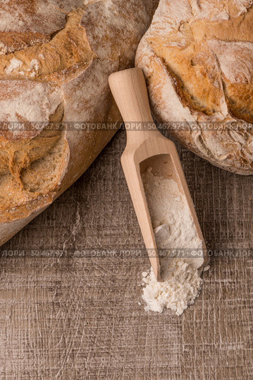 Rustic bread and wheat on an old vintage planked wood table. Стоковое фото, агентство Ingram Publishing / Фотобанк Лори