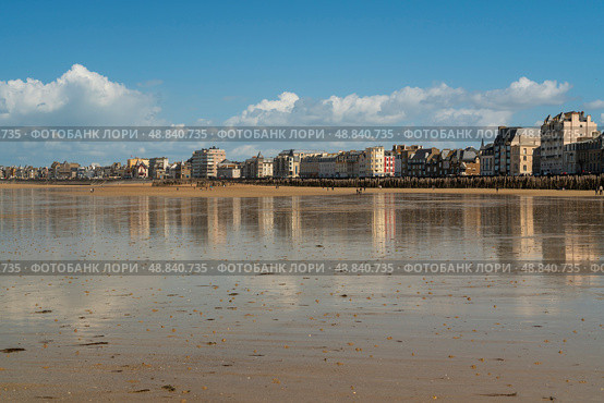 Saint-Malo, Brittany, France, 05.04.2019: View of the promenade and the beach with wooden breakwaters at low tide on a sunny summer day. Редакционное фото, фотограф Ula Ulachka / Фотобанк Лори