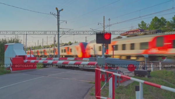Saint-Petersburg, Russia - Aug 17 2022, 4k, Closed railway crossing waiting for the passing train "Lastochka", Saint-Petersburg, Russia. Редакционное видео, видеограф Сергей Богомяко / Фотобанк Лори