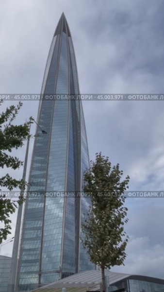 SAINT PETERSBURG, RUSSIA - September 27, 2024: Vertical video from new East Park with green trees to the 87 - story skyscraper Lakhta Center - popular city landmark and tourists attraction. Редакционное видео, видеограф Виктория Катьянова / Фотобанк Лори