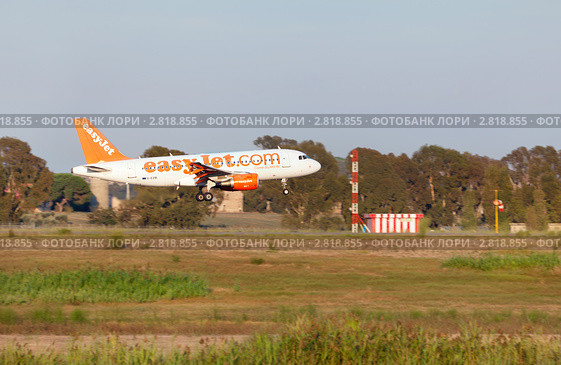 Самолет Airbus A319-111 авиакомпании-дискаунтера Easy Jet совершает посадку на взлетную полосу аэропорта Фьюмичино, Рим, Италия. Редакционное фото, фотограф Николай Винокуров / Фотобанк Лори