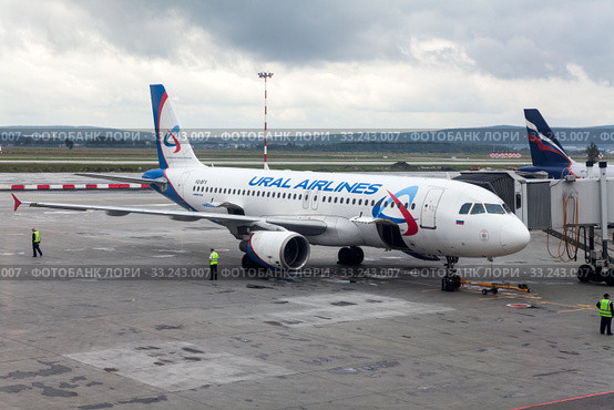 Самолет авиакомпании Уральские Авиалинии (Ural Airlines) пристыкован трапом к терминалу аэропорта Кольцово. Екатеринбур (2015 год). Редакционное фото, фотограф Кекяляйнен Андрей / Фотобанк Лори
