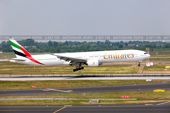 Самолет Boeing 777-300 авиакомпании Emirates совершает посадку на взлетной полосе аэродрома (2011 год). Редакционное фото, фотограф Николай Винокуров / Фотобанк Лори