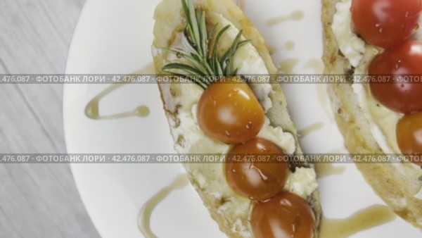 Sandwiches with cottage cheese and cucumber slices, cherry tomatoes on a white farm baguette on a wooden table. View from above. Стоковое видео, видеограф Ярославский Максим / Фотобанк Лори
