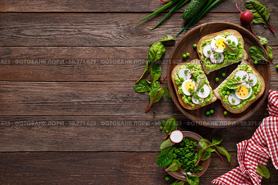 Sandwiches with wholemeal bread, hummus or puree of fresh green peas, radish, cucumber, boiled egg, green onion and chard. Стоковое фото, агентство Ingram Publishing / Фотобанк Лори