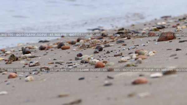 Sandy beach. Waves throw rocks on the sandy shore. High quality 4k footage Песчаный пляж. Волны выбрасывают камни на песчаный берег. Отснятый материал высокого качества в формате 4k. Стоковое видео, видеограф Egor Sarantstv / Фотобанк Лори