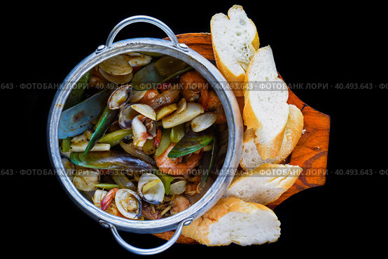 Sautéed seafood in pot close up isolated on black background side view. Стоковое фото, фотограф Татьяна Терехина / Фотобанк Лори