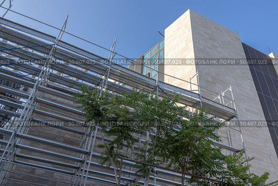 Scaffolding for cladding the exterior walls of a building under construction. Scaffolding for construction workers for the convenience of working at height. Стоковое фото, фотограф Эдуард Белкин / Фотобанк Лори