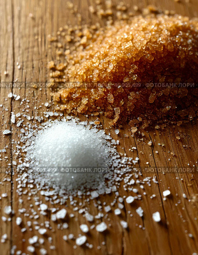 Scattered white and brown granulated sugar on wooden kitchen table. Стоковое AI-изображение, AI-художник Сергей Елизарьев / Фотобанк Лори
