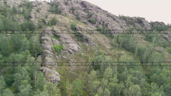 Scenic landscape featuring steep mountains and dense forests in a valley, with dramatic cloud formations above, highlighting the tranquility of the natural environment. Стоковое видео, видеограф Ирина Ручушкина / Фотобанк Лори