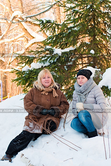 Счастливая семья. Мама с дочкой сидят зимой под ёлкой. Стоковое фото, фотограф Игорь Низов / Фотобанк Лори